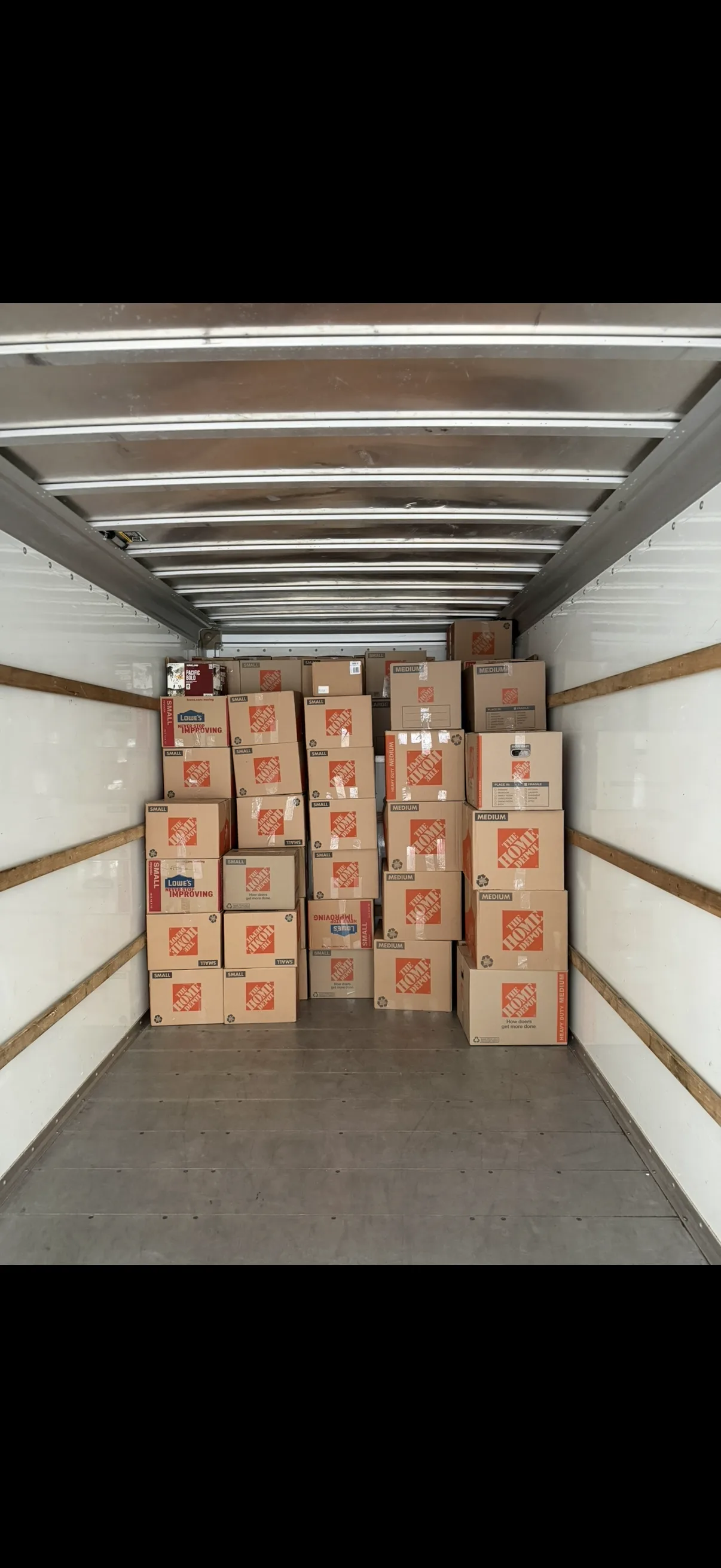 Moving truck staged with packed household boxes
